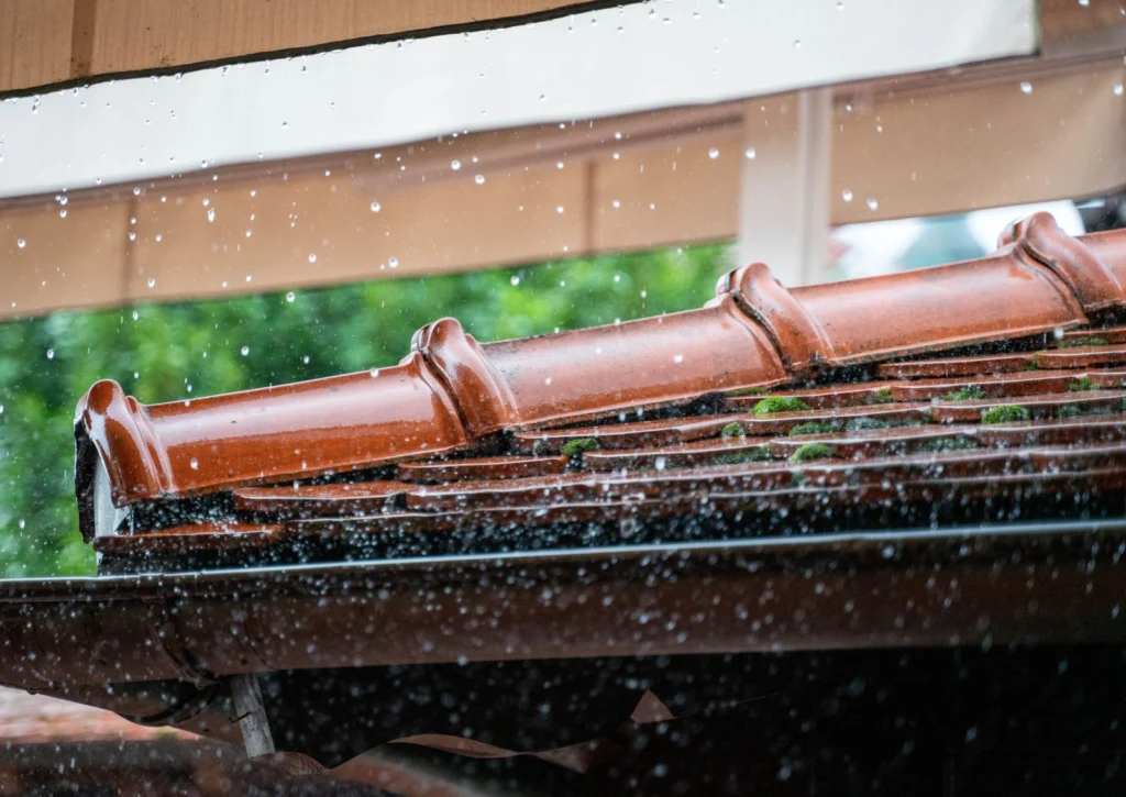 Pluie abondante sur une toiture et sa gouttière